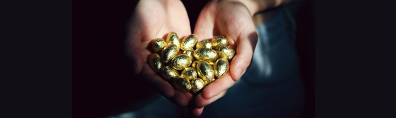 hands cupped together holding what appears to be gold foil wrapped chocolates